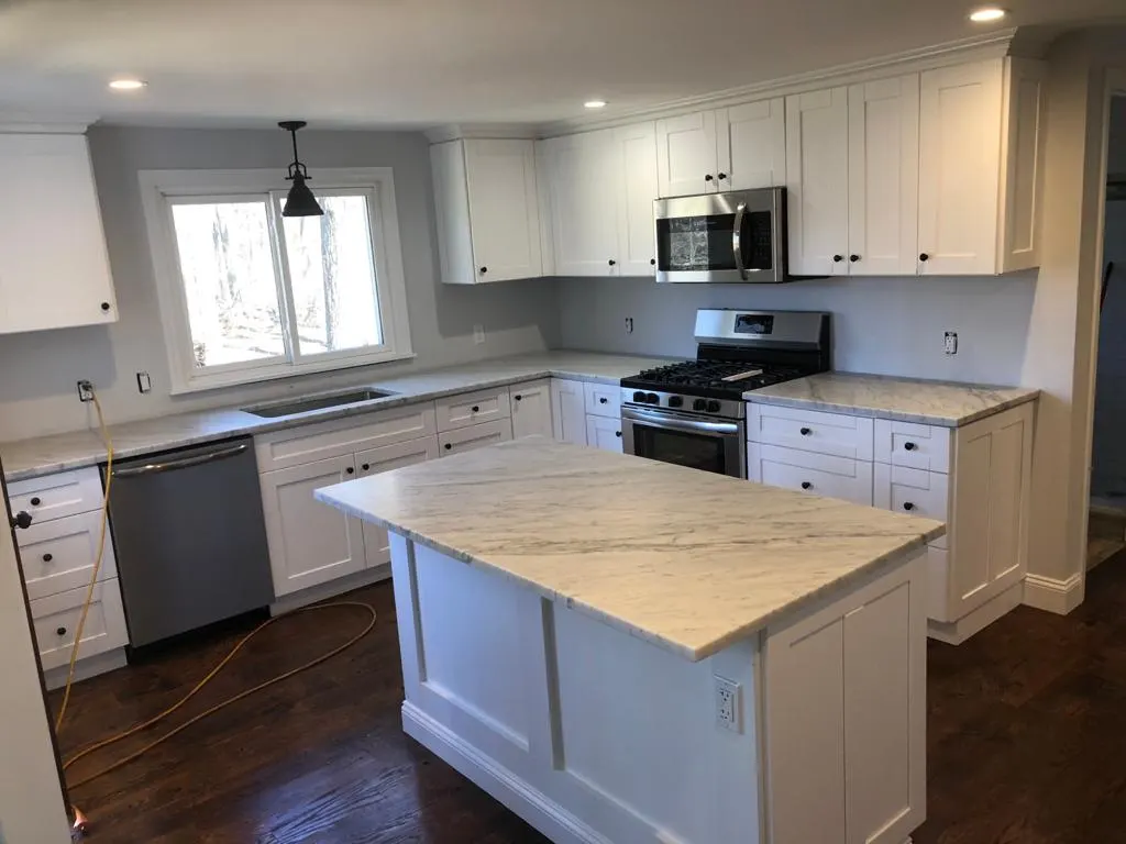 White kitchen island with a light veined countertop