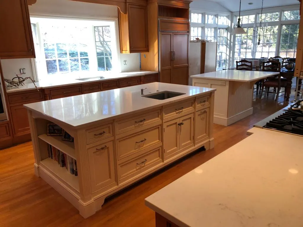 Kitchen island with a white countertop and wood cabinetry